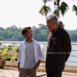 Mahathir Mohamad Instagram - Saya ditemuramah Umar Amirul Shakur Haiccal untuk satu rancangan di YouTube. Umar baru berusia 12 tahun dan minat bolasepak. Tanya Umar, macam mana nak capai umur 97 tahun. Saya jawab kena tunggu lagi 85 tahun lagi lah baru tahu macam mana boleh capai. Dalam temuramah tadi, saya cukup seronok dengar celoteh Umar dan dia begitu petah bercakap. Banyaklah soalan ditanya umpamanya bagaimana saya di zaman bersekolah, apa pesanan ibu saya, kenapa bina KLCC, Putrajaya, KLIA, pandangan bolehkah jadi influencer saja tanpa belajar dan banyak lagi. Umar tanya saya, kenapa ada helmet Star Wars dalam pejabat saya - The Mandalorian dan Darth Vader. Sebenarnya helmet ini dicetak mengguna 3D-printer. Saya berminat dan beli printer ini untuk buat sendiri beberapa barang, cumanya perlu belajar program dan sabar tunggu hingga siap. Kalau dahulu saya ukir kayu guna pisau dan tangan, sekarang semuanya pakai mesin. Lebih mudah. Cuma perlu faham dan mahir untuk program mesin saja. Semasa bergambar di hujung temuramah, Umar minta posing dengan “mini love”. Sengaja saya usik minta jelaskan apa itu “mini love”. Yang saya faham, rapatkan ibu jari dan jari telunjuk tu itu simbol minta duit! Umar terangkan simbol love asalnya besar, kena guna dua tangan untuk cantum jadikan love, tapi ada orang cipta pula simbol love dengan dua jari. Pandai dia menjawab. Saya pesan kepada Umar, rajin-rajinlah belajar supaya masa depan lebih terjamin. Semoga impiannya tercapai suatu hari nanti. InsyaAllah. Perdana Leadership Foundation