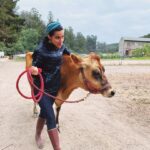 María Gabriela de Faría Instagram – #TBT of the first time I milked a cow 🐮

Back in 2020 Julia and Ryan from @blooming.energy invited Chris and I to stay at the farm (@dare2dreamfarms ) and work on the land for as long as we wanted to.
I left that place a different person and I will always be eternally grateful to them for giving me perspective.
The cow pooped on me, of course.
The chickens kept running into absolute death, don’t ask me why.
The goats threw parties whenever we weren’t looking. 
Poop, food scraps and all that organic “waste” was gold.
We found corpses of animals all around and I finally understood there’s not life (or food) without death.

I went there a city vegan and I left with a huge identity crisis 🤣 but convinced that my personal path was caring about the how more than the what.
How you eat vs what you eat.

Controversial topic.
Life expanding identity crisis for me ❤️
•
•
•
#TBT de la primera vez que ordeñé una vaca 🐮

En el 2020, Julia y Ryan de @blooming.energy nos invitaron a Chris y a mí a quedarnos en la granja y trabajar en la tierra todo el tiempo que quisiéramos.
Me fui de ese lugar como una persona diferente y siempre les estaré eternamente agradecida por regalarme perspectiva.

La vaca se me cagó encima, por supuesto.
Las gallinas corrían hacia la muerte absoluta todo el tiempo, no me pregunten por qué.
Las cabras hacían fiestas cuando no mirábamos.
La caca, los restos de comida y todos esos “desechos” orgánicos eran oro.
Encontramos cadáveres de animales por todas partes y finalmente entendí que no hay vida (ni comida) sin muerte.

Entré a la granja vegana de ciudad y salí con una crisis de identidad enorme 🤣 pero convencida de que mi camino personal era preocuparme/ocuparme por el cómo más que por el qué.
Cómo comes versus qué comes.

Tema controversial.
La crisis existencial que me expandió ❤️