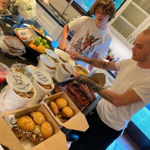 Mark Sheppard Instagram - My boys opening up the bounty that is @sweets2savory delivery! Incredible food from my old friend Chef @timabell Homemade sausage, brisket, pulled pork with vinegar sauce, sous vide pork belly sliders, smoked pork ribs, polenta fries, greens and beans!!!! If you are in LA, give them a try. #supportlocalbusiness