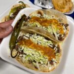 Mark Wiens Instagram - One of the great taquerias of #Tucson, this is the Taco Yaqui, an open faced green chile, cheese, bacon, carne asada, on overlapping flour tortillas. #MexicanFood #Sonora #tacos #Tucson Aqui Con El Nene