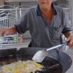 Mark Wiens Instagram - That splatter move!! He’s been frying oyster omelets for over 60 years!! Oyster Omelet (หอยทอด) 📍 Wang Hoy Tod (เว้งหอยทอด) #legend #Bangkok #ThaiFood Bangkok, Thailand