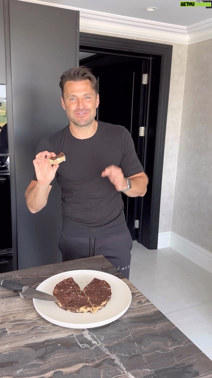 Mark Wright Instagram - VIRAL PEANUT BUTTER CHOC BARS. Had to try these and had to put my own twist on them. 🍫🥜☕ This is just one of the hundreds of recipes on our @_livewright_ coaching app. Signing up though means your entire meal plan gets tailored to you and your goals. So if you want to put on muscle or lose fat but you don’t like onions or you’re a vegan then we would build a plan around exactly that. INGREDIENTS: 2/3 cup peanut butter (melted) 1/2 cup honey 1 tsp coffee extract (could swap this for vanilla) 6 lightly salted rice cakes 100g dark choc (70% is great) 2 tsp coconut oil Flaky sea salt to top METHOD: 1. In a bowl, mix together the peanut butter, honey, and coffee extract until smooth. Crumble in the rice cakes and mix. 2. Line a cake tin with parchment paper and then use a spoon to press the rice cake mixture tightly into the pan, ensuring it’s evenly distributed. Place in freezer to set. 3. Melt the chocolate and coconut oil together (I did mine in a pyrex dish over a pan of boiling water) until smooth and glossy. 4. Remove the base from the freezer and pour the melted chocolate on top. Spread until it evenly coats the rice cake mixture. Sprinkle with flaky sea salt. Transfer back to the freezer for 30-40 mins, or until chocolate is set. I then added a bit more sea salt. Who’s making these?!