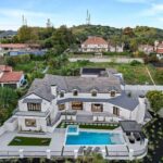 Mary Fitzgerald Instagram - Just Listed In Villa Park - 18541 Valley Dr. - $5,495,000 8 Beds / 8 Baths / 10,329 Sq. Ft. / 39,335 Lot Size Located in Orange County's prestigious Villa Park and set behind private gates on an elevated lot, this newly remodeled contemporary estate offers breathtaking views of the city and Catalina Island. Boasting 8 bedrooms, 8 baths, and over 10,000 sq. ft. of living space on an expansive nearly 40,000 sq. ft. lot, the home comes replete with every amenity necessary for luxe living and top-class entertainment. Enter into a light-filled foyer with double-height ceilings and a wrap-around staircase accentuated by a chandelier. The main level enjoys an open floor plan with flowing spaces accentuated by White Oak flooring. The cozy living area is framed by a wooden feature wall and marble fireplace. Adjacent to this, the dining area is replete with its own wooden accent feature wall, custom-built buffet cabinets, and designer chandelier. The chef's kitchen features a full set of Thermador appliances, custom White Oak cabinetry, leathered granite backsplash and countertops, and a large cascading center island with seating. A spacious breakfast nook with additional storage and views completes the kitchen area, with its own semi-private room with a fireplace perfect for an additional family/TV room. This entire level enjoys access to the sweeping yard with a resort-style pool and spa with smart controls, a Cantilever pergola with a rainfall feature, and a built-in BBQ, all enjoying more gorgeous views. The split-level primary suite enjoys high ceilings, a sitting area, fireplace, private balcony with sprawling unobstructed views, his-and-her closets, and a breathtaking spa-like bathroom with dual vanity, touchless heated smart toilet, large walk-in steam shower, freestanding bathtub, and sauna. Additional amenities include a secondary owner's suite with a large bathroom, a 1,000 sq. ft. theater with 11.2 Dolby Atmos system, two office spaces, a gym with massage room (could be wine or cigar room), a 4-car garage, and a 20-car motor court. Listing Agents: @alexanderhuerta_ @jasonoppenheim