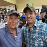 Mike Rowe Instagram - Sunday, outside of @BelAirLiquors there was thunder and lightning and an inch of rain falling every 30 minutes. Inside, there were over 100 well-mannered people with excellent taste in whiskey, waiting patiently in line to shake my hand and grab a photo. What do you say to people who brave a hurricane to say hello and buy a signed bottle of your grandfather’s whiskey? Well, if you’re me, you say “thanks,” as sincerely as you can, over and over again. Among others was the Pelletier family, all 14 of them. This is the largest family I’ve ever posed for a photo with, and I’m not even sure they were all represented. Once you show up with 14, you have to assume there’s another 3 or 4 in the wings, right? I don’t remember each of their names, but I think it was young Jake (?) who made a crab out of stones, mounted it in a very tasteful frame, and presented it to me as a gift. Thanks, Jake. Very thoughtful. I’ll hang it in a place of prominence upon my return. I met Nick Berte, who built a very cool Double Whiskey Barrel Liquor Cabinet, that opens and closes with the touch of a remote control. The store is raffling it off at the annual Maryland Italian Festival to raise money for charity. I met Mike Griffith, who is a Maryland State Delegate for District 35B. I know this because he gave me his business card, which I I’ll hang on to. You never know when you need the services of a state delegate, right? And then there was Jon, a Baltimore County Detective who was shot four times by a creep with an AR-15 just a few months ago. Jon survived, happily, and was released from the hospital not long ago. His wounds are very serious, but he stood in line like all the others, thanked me for supporting first responders, and gave me a patch that said, “Don’t Die Easy.” What do you say to a guy who risks his life to serve and protect you, gets damn near killed, and then comes out on a rainy Sunday to shake your hand? If you’re me, you say “thanks,” as sincerely as you can, over and over again. I proprietor, Larry Dean, and his hardworking family. Big thanks to all of you guys, for making it happen. And congratulations for having such awesome customers. Till next time. Belair Md