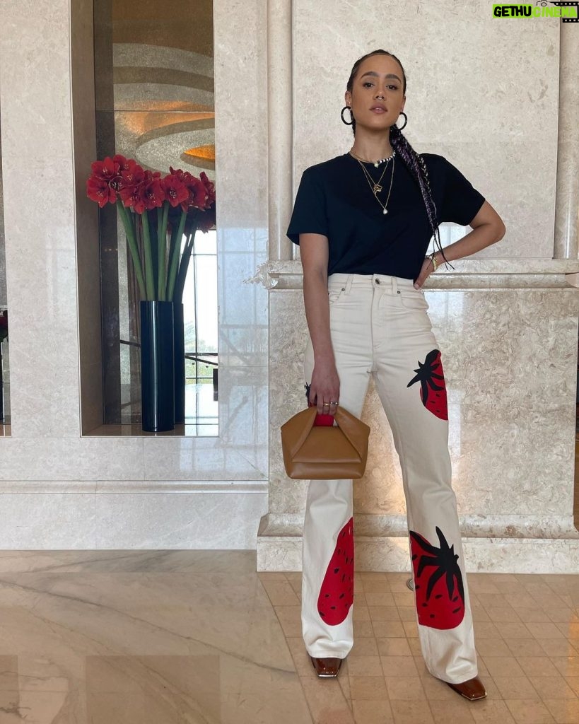 Nathalie Emmanuel Instagram - 🍓🍓🍓 My look for second day @mefcc in Abu Dhabi! Styling: @chercoulter Jeans and bag: @jw_anderson Tshirt: @sunspelclothing Jewellery: @missoma, @mejuri and @mathe_jewelry Shoes: @aldo_shoes Sunglasses: @akonieyewear Nose ring: @laura_bond_jewellery Saadiyat Island