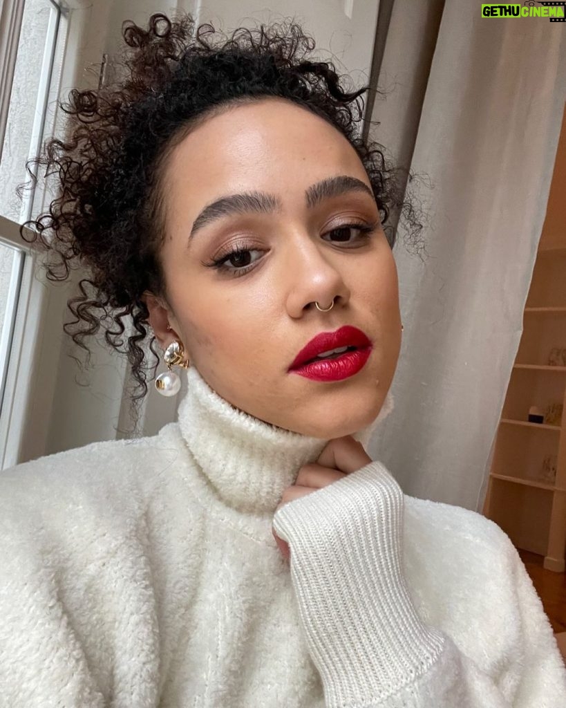 Nathalie Emmanuel Instagram - Virtual press for #LastTraintoChristmas (Out on Sky Cinema December 18th) requires snowy jumpers, red lips and bauble like pearl earrings… and hair and make up by @norarobertson_mua. 🚇🎁🎄 Jumper: @nanushka 💚🌱 Earrings: @miumiu ⚪️⚪️
