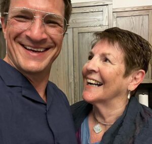 Nathan Fillion Instagram - This is my mom, God rest her soul (not dead). She’s an excellent cook, a fantastic public speaker, and though she says she doesn’t like animals they are still drawn to her like bees to honey. She goes by many names, I assume to help avoid the authorities, but most people know her as Cookie (short for Cookie Birthday Cake). She was my first experience with celebrity, because people still constantly stop her to say how she changed their lives as their teacher. She’s been my teacher, too. The lessons she’s taught me have carried me on to many, many successes. If anyone ever accuses me of being an excellent human, I can invariably trace it back to how she has taught me to behave. Mom, have the happiest of birthdays today, and know- I AM being haive!