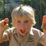 Robert Clarence Irwin Instagram - The love for chameleons must be genetic. 5 year old me with a tiny chameleon on my head and my dad with a big, full grown adult!