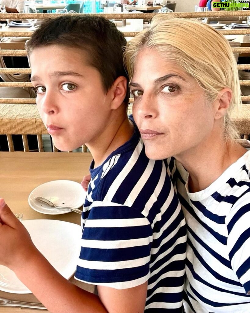 Selma Blair Instagram - My Saint, Arthur, happy birthday 🎂. This has been the most incredible life with you. Forever my favorite, I know you are going to have the best year yet. I am so proud of who you are and have become. Usually 🦁. The most adorable little kid has grown into a 12 year old!!!! 🐣🦅. I love you and I like you. Massively. 💛 mom Image descriptions: 1. A younger Arthur sits inside a brown handbag next to Selma while both look at the camera. They are poolside. 2. A 12-year old Arthur with short hair sitting on his motorbike and looking at camera. 3. Selma and Arthur wearing blue and white striped shirts sitting next to each other and looking at camera. 4. Arthur and Jason are on a boat with the sun and ocean behind them. They are smiling and looking at camera. 5. Selma, Arthur, and her dog Scout laying in bed. 6. Arthur in a striped sweater cuddles their dog Pippa. 7. An older photo of Selma and Arthur. Selma has long hair and they are smiling at the camera. 8. Selma and Arthur sit in bed. Selma is looking at Arthur and Arthur is looking into the distance. 9. Arthur in a blue shirt and short hair cuddles their dog Scout. 10. A younger Arthur with wild hair holding a guitar and smiling at camera.