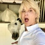 Selma Blair Instagram - This is my social life and it’s pretty grand. Mr Nibbles gives me all the emotions. 🎭 It’s getting hot out here, drink your water 💁🏼💦 Image Descriptions: Image 1: Selma has short blonde hair and wears a white long sleeve shirt. She is smiling and standing next to her white horse. Image 2: Selma wears a white long sleeve, tan pants, boots, and a helmet and is sitting outside. Video: Video of Selma riding her horse Image 3: Selma poses with her horse Image 4: Close up image of Selma in her riding gear. Image 5: Selma poses with her horse.