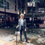 Selma Blair Instagram - London 🖤. It was time. We love you. I only wish I could stay longer. This time in London has been so good for my northern soul. And my son was enchanted as well. We met our dearest friends. Been too long. and I’m changed. Thank you Image descriptions: Image 1: Selma has short blonde hair and is standing with the London skyline behind her. Image 2: Selma and Arthur sit in separate chairs. Arthur has short brown hair and sitting on the left in a chair in a hotel lobby with black and white floor. Image 3: Silhouette of Selma holding her cane with a long coat on. Image 4: Arthur is on left wearing black jacket with a hoodie, hugging Stella, who is wearing long sleeve grey shirt. Image 5: Selma and Arthur walking to music that Stella, whose back is to the camera, plays on her phone. Image 6: Selma is standing with her cane next to Vanessa Kingori who is on the left wearing a light green outfit with her arm around Selma. Image 7: Selma is wearing a grey suit and holds her cane. She is standing outside, surrounded by lit up trees. Image 8: Selma is on the left kneeling with her cane in front of her next to Katie who has brown hair and is wearing glasses and wearing white boots. Image 9: Black and white photo of Selma with Anya Taylor Joy, who has long, straight blonde hair. Image 10: Video of Selma and Arthur walking on the street in London. London, England