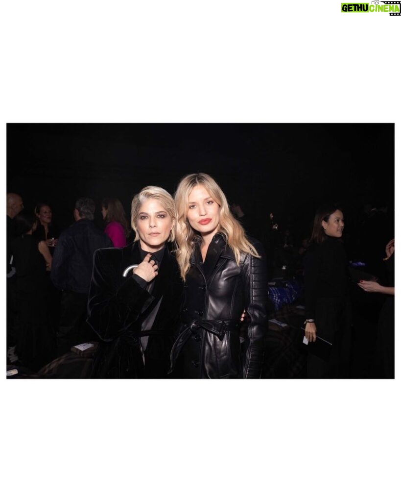 Selma Blair Instagram - The evening of Burberry. 🗡 Image Descriptions: Image one: Selma has short blonde hair and wears a long black velvet coat. She is standing on the runway at the Burberry show with her cane with one hand in her pocket. Image two: Selma stands in front of orange wall. Image three: Selma sits with Edward and Naomi. Edward is wearing all black and Naomi is wearing a grey suit. Image four: Selma and Georgia are standing and both wearing black. Image five: Selma is standing in profile wearing a white robe while getting her hair done. Image six: Selma leans against an orange wall and is looking to the left.