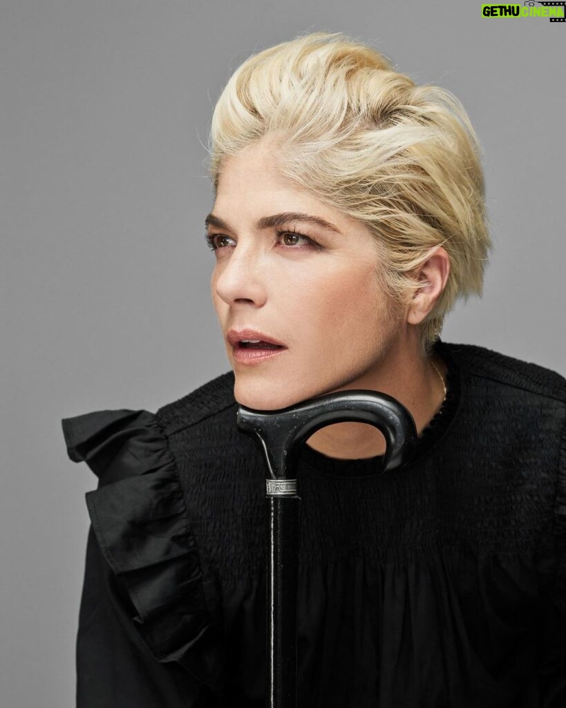 Selma Blair Instagram - “In the meantime, I took a job folding T-shirts at the Gap on Seventy-Fifth and Lex. I loved folding clothes on the folding board. I loved the Gap pens we won if we sold the most product that day. I loved the employee discount and the tap of the register keys as I printed out gift certificates and ran exchanges. In a way, working at the Gap was the perfect job for me, a place to channel my deep need for organization.” — Excerpt from Mean Baby Image one: Selma has short blonde hair, is wearing a black shirt and is resting her chin on the handle of her cane looking off to the right. Image two: Selma has short blonde hair, is wearing a black shirt and holding her cane in her right hand as her whole body is facing right. Image three: Selma is wearing black jeans, shirt and shoes while she is jumping above her cane, which she is holding in her right hand. Image four: Selma is on set wearing a jacket. Her right knee is bent as she looks directly at the camera. Image five: Selma is seated and looking directly at the camera while she leans on her cane. Image six: Written text from Mean Baby.