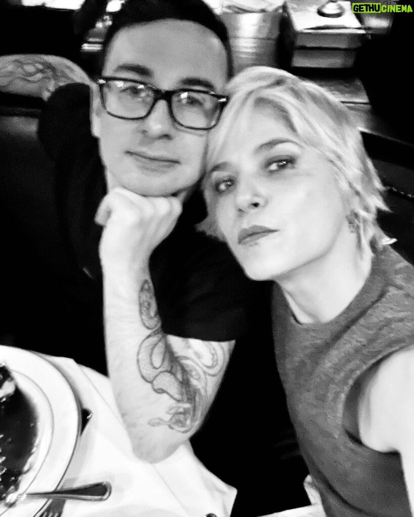 Selma Blair Instagram - 🤍🗽 Image Descriptions: 1. Selma has short blonde hair and is sitting on brick balcony wearing a grey coat with black collar. 2. Black/white photo of Selma and Christian Siriano at dinner. Christian has short dark hair and is wearing a black tshirt. 3. Selma is wearing a black sweater and sunglasses. A man is seated behind her playing with her dog Scout. 4. Black/white photo of Selma, Art Tavee and Carolyn Griffin at dinner. Art has short light hair and wears glasses and Carolyn has shoulder length hair. 5. Selma, Troy, Art, and Carolyn posing together for a selfie outside at dinner. 6. Selma posing in the mirror in a hotel bathroom. There are pink flowers in the focus of the photo. She wears a black sweater with a white collared shirt under it. New York, New York