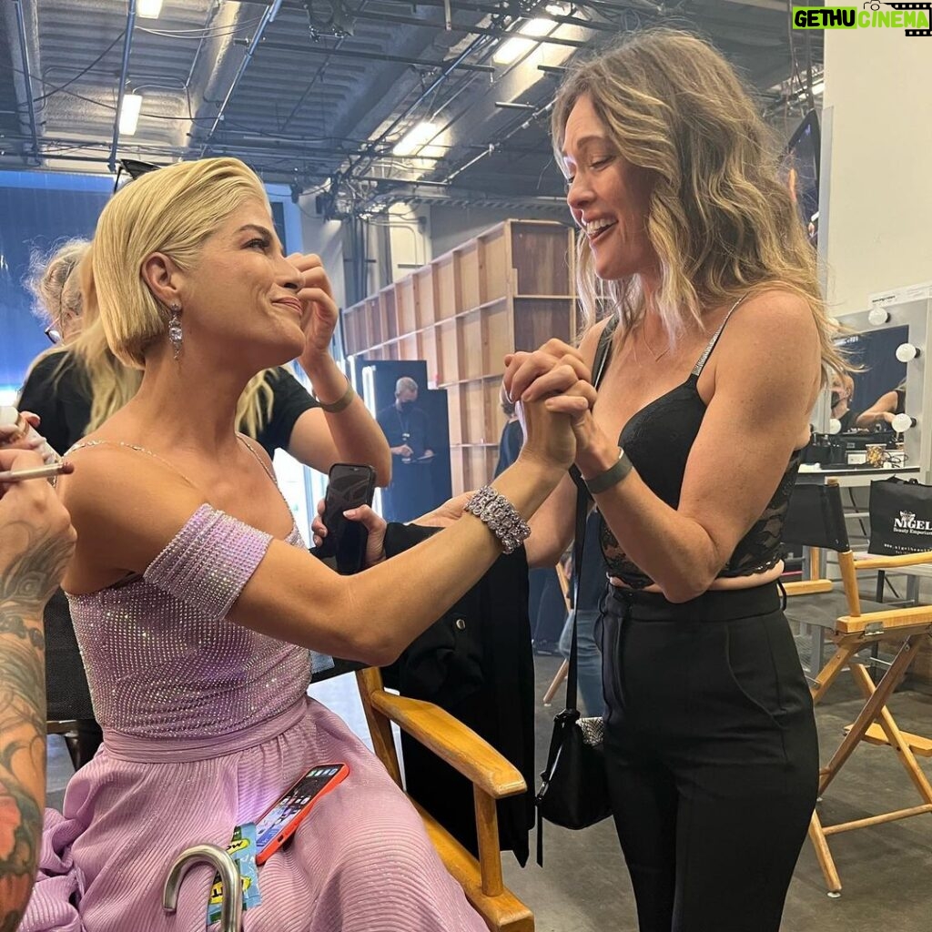 Selma Blair Instagram - About last night…💜 And all the love to @sashafarber1 and my crew of greats✨ IMAGE 1: Selma has short blonde hair and is being lead downstage into the spotlight by her partner Sasha who has short brown hair and is wearing a lavender suit. IMAGE 2 : Selma has short blonde hair and is seated in a chair in wearing a long lavender dress while she looks to the left and holds hands with Amy, who has dark blonde hair and is wearing black pants and a black top. IMAGE 3: Selma stands in a lavender dress with her friends Jamie, Andraéa, Hylda, her son Arthur and Jason. IMAGE 4: Selma has short blond hair and is standing with her arm around her son Arthur, who is wearing a navy jacket. IMAGE 5 - Selma and Sasha hug on stage at the end of their performance.
