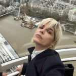 Selma Blair Instagram - London 🖤. It was time. We love you. I only wish I could stay longer. This time in London has been so good for my northern soul. And my son was enchanted as well. We met our dearest friends. Been too long. and I’m changed. Thank you Image descriptions: Image 1: Selma has short blonde hair and is standing with the London skyline behind her. Image 2: Selma and Arthur sit in separate chairs. Arthur has short brown hair and sitting on the left in a chair in a hotel lobby with black and white floor. Image 3: Silhouette of Selma holding her cane with a long coat on. Image 4: Arthur is on left wearing black jacket with a hoodie, hugging Stella, who is wearing long sleeve grey shirt. Image 5: Selma and Arthur walking to music that Stella, whose back is to the camera, plays on her phone. Image 6: Selma is standing with her cane next to Vanessa Kingori who is on the left wearing a light green outfit with her arm around Selma. Image 7: Selma is wearing a grey suit and holds her cane. She is standing outside, surrounded by lit up trees. Image 8: Selma is on the left kneeling with her cane in front of her next to Katie who has brown hair and is wearing glasses and wearing white boots. Image 9: Black and white photo of Selma with Anya Taylor Joy, who has long, straight blonde hair. Image 10: Video of Selma and Arthur walking on the street in London. London, England