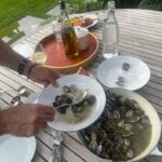 Stanley Tucci Instagram - Serves 4 (in my house) 1kg clams Half an onion diced One garlic clove split in two Two pepperoncini 1 cup of white wine 1 sprig of thyme 2 sprigs of parsley Handful chopped parsley Evoo Clean the clams by submerging in cold very salty water (this purges them of grit!) Discard any open ones. Sauté the onion and garlic in a pan in evoo Add one or two pepperonci 🌶 Add the white wine, raise heat to high to burn off alcohol Add the clams and a sprig of thyme, two sprigs of parsley 🌿 Season with salt and pepper Place a top over the pan and the clams will start to open. After two minutes remove the cover and shake the pan gently. If the clams have not started to open place lid back on for a minute Make sure all (or nearly all) the clams have opened. Discard those that have not. Lower heat to a simmer and add chopped parsley and a slug of EVOO Serve with toasted bread (and in my case a tomato salad). This is my wife’s favorite. (One of, she’s a glutton).