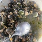 Stanley Tucci Instagram - Serves 4 (in my house) 1kg clams Half an onion diced One garlic clove split in two Two pepperoncini 1 cup of white wine 1 sprig of thyme 2 sprigs of parsley Handful chopped parsley Evoo Clean the clams by submerging in cold very salty water (this purges them of grit!) Discard any open ones. Sauté the onion and garlic in a pan in evoo Add one or two pepperonci 🌶 Add the white wine, raise heat to high to burn off alcohol Add the clams and a sprig of thyme, two sprigs of parsley 🌿 Season with salt and pepper Place a top over the pan and the clams will start to open. After two minutes remove the cover and shake the pan gently. If the clams have not started to open place lid back on for a minute Make sure all (or nearly all) the clams have opened. Discard those that have not. Lower heat to a simmer and add chopped parsley and a slug of EVOO Serve with toasted bread (and in my case a tomato salad). This is my wife’s favorite. (One of, she’s a glutton).