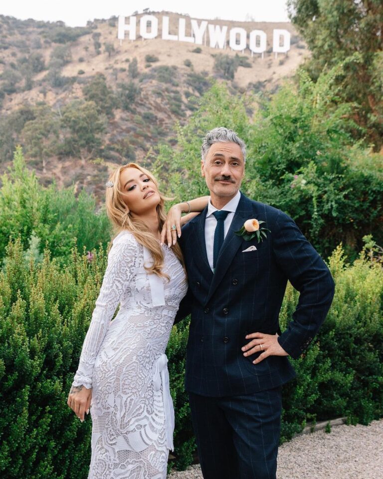 Taika Waititi Instagram - Happy anniversary, @RitaOra and @TaikaWaititi! To celebrate their special day, the couple has shared their never-before-seen wedding album with Vogue. Over the past year, information about their nuptials has spread like wildfire across the internet—not all of it correct. “It’s actually been quite entertaining for us to see the different stories people made up and all the while getting to keep it to ourselves,” Rita admits. “And, I love that we now get to share what really happened—and to do it on our one year anniversary no less!” “Rita [Ora] proposed to me, and I said ‘yes’ instantly,” filmmaker Taika Waititi says of how he and the singer-songwriter became engaged. While the pair first met at a barbecue in 2018 that Taika hosted at his house in L.A., it wasn’t until 2021, when they were both filming in Australia, that they began dating. Rita popped the question while on vacation in Palm Springs in the summer of 2022, and they planned an impromptu wedding to be held in Los Angeles a few weeks later, on August 4. “It wasn’t in London or in France like everyone reported,” Taika clarifies. “It was in L.A. with a small group of friends.” See all the photos from their big day at the link in our bio. Photo: @jackgorlin