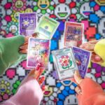Takashi Murakami Instagram – 【Tonari no Zingaro】

12月20日(水)22時よりWEBショップにて、
「Murakami.Flowers Collectible Trading Card – 108フラワーズ」を予約販売いたします。
⁡
村上初のトレーディングカード
《Murakami.Flowers Collectible Trading Card – 108フラワーズ》
⁡
2022年4月にリリースされたNFT ART「Murakami.Flowers」で生成された11,664種のフラワーNFT ART達の中の
108個のイメージはドット柄でしたが、カードではリアルなイラストへ変身しました。
コレクターズアイテムとして、ハイクオリティなアートカードをご堪能いただけます。
⁡
1BOX（12パック入り）での販売となり、日本語版と英語版をご用意しております。（購入時に別々のエントリーとなります）
なお、少量のご用意となりますので、お見逃しのなきよう！！
⁡
また今回の販売に合わせ、《Murakami.Flowers Collectible Trading Card – 108フラワーズ》を
より楽しくする周辺グッズ合計4点もローンチいたします。
⁡
108種類+スペシャルなカード数種類のバリエーションから、どんなカードが手に入るかは開封してのお楽しみ。
もしかしたら超超レアなカードも当たっちゃうかも。
あなたのコレクションに新たな輝きを加えること間違いなしです。
⁡
108種以上ものラインナップから、きっとあなたにぴったりなお花ちゃんが見つかるはずです。
そして、ぜひコンプリートを目指してみてください。
⁡
カード制作部 KAZAMI
⁡
#MurakamiFlowersCollectibleTradingCard
#tonarinozingaro #kaikaikiki #takashimurakami #takashipom #nakanobroadway #officialsouvenirshop #hypebeast
ーーーーーーーーーー