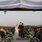 Taylor Lautner Instagram – CEREMONY
The ceremony was something we’ve been dreaming of for a long time. Along with the help of our wedding planners, we put in a lot of thought designing what exactly we wanted for this monumental moment and it came together even better than we had imagined. The ceremony location was at one of the highest points on the Epoch property which overlooks miles of wine country in Paso Robles. The colors surrounding us at this time of year are exactly why we love the Fall season so much. In an effort to provide shade and intimacy we installed a wooden truss system and semi sheer white draping, to create a relaxing and partially shaded ceremony location. White florals and lush greenery trailed up the columns of the wooden
structure and down the ceremony aisle. Beautiful white floral blooms surrounded us on a circle riser stage. As guests arrived by shuttle, they were invited to take a walk through the vineyard to the ceremony site. Our pastor and dear friend Judah Smith officiated the ceremony. It couldn’t have been more perfect. We exchanged hand written vows in front of the people we love most. Looking around and seeing the faces of each and every single person there, really put into perspective what is most important in life. Love. The sun set just as we said our “I Do’s” and the most beautiful pink sky was our backdrop as we walked back down the aisle as Mr. and Mrs. Taylor Lautner for the first time. 

Planning and Event Design @samkoma.world
Venue @epochwines
Photography @nicoleivanovphoto
Lighting @tn_event_designs
Floral Design @noonansdesigns 
Wedding Dress @winniecouture 
Grooms Tux @dolcegabbana