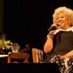 Alcione Instagram – Já está disponível, em todos os aplicativos de música, o álbum comemorativo aos 50 anos de carreira da Marrom, gravado no Theatro Municipal do Rio! (Equipe)

Brahma e Secretaria de Estado de Cultura e Economia Criativa do Rio de Janeiro, através da Lei de Incentivo à Cultura, apresentam: 

ALCIONE 50 ANOS 

O show, que também está na íntegra no YouTube da @biscoitofino por 72 horas, tem direção musical de Alexandre Menezes e geral de Solange Nazareth, traz um mosaico formatado por medleys com 65 músicas das mais diferentes fases da vitoriosa carreira de Alcione: “A Loba/Ou Ela, Ou Eu”, “Sufoco”, “Meu Ébano”, “Estranha Loucura”, “Você Me Vira a Cabeça”, “Além da Cama”, “Garoto Maroto”, “Faz Uma Loucura Por Mim”, “Nem Morta”, “Gostoso Veneno” e muitas outras! 

Além da Banda do Sol que a acompanha por décadas, integrantes da Orquestra Sinfônica  Maré do Amanhã, dançarinos da Academia Marcello Chocolate e Sheila Aquino e da Cia. Cenarte Dimensões; além, é claro, da Estação Primeira de Mangueira, fizeram parte da gravação. 

O espetáculo que deu origem ao novo DVD da cantora abriu ao som eletrizante do Ilé Àṣẹ Ọbalúwáiyé Jagun, casa do Pai Celinho de Omolu, e com a voz poderosa de Maria Bethânia que estava na plateia) recitando os versos da autobiográfica “Resumo” (música de Roberto Correa e Sylvio Son). 

“Alcione 50 Anos” não é apenas o álbum que celebra o cinquentenário de carreira dessa artista que é sinônimo de brasilidade. Conta uma história de sucesso construída com muito trabalho e norteada por um amor extremo ao ofício. -“Cantar é ofício e paixão. E só tenho a agradecer àqueles que me auxiliaram, conduziram-me até aqui. Agradeço, principalmente, aos fãs. Sem eles não existiriam artistas”, resume Alcione.