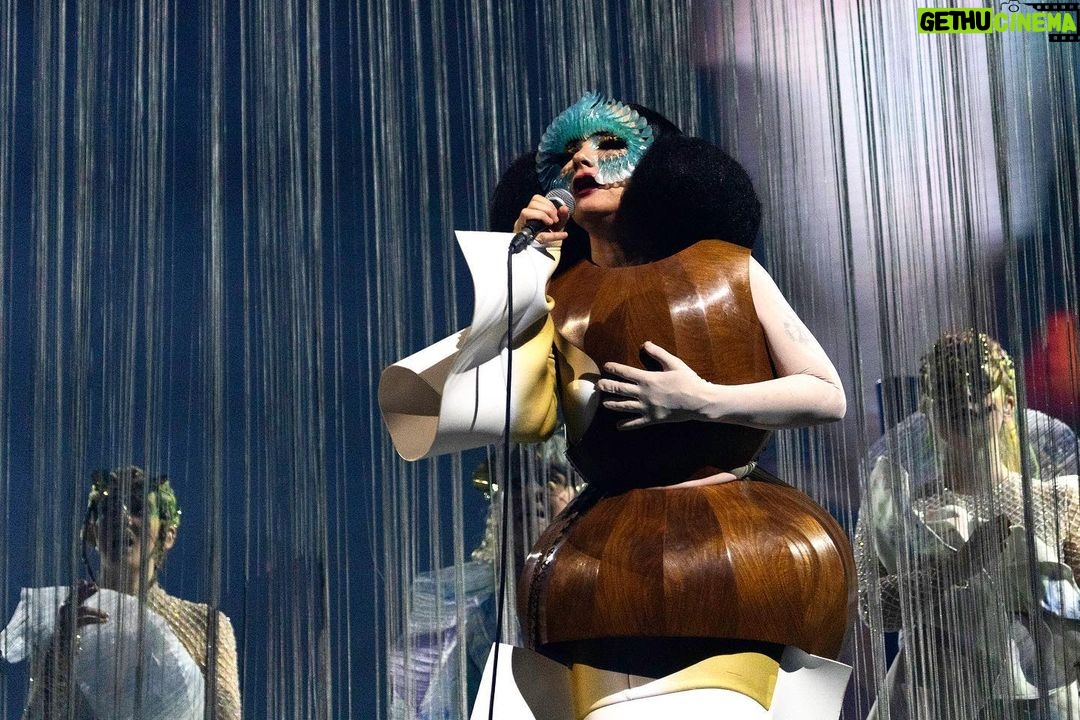 Björk Instagram - thanks for tonight Leipzig! musicians : @viibraflutes @bergurth @manudelagomusic @katiebuckleyharpist bjork wood sculpture outfit @zomer.official @xylomancia_ dress @kwkbykaykwok headpieces @james.t.merry sphæra dress @irisvanherpen musicians outfits @balmain hair @johnvialhair musicians hair @tomikono_wig makeup @isshehungry styling @eddagud photos @santiagraphy Leipzig, Germany