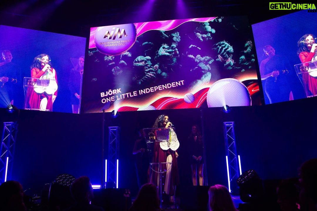 Björk Instagram - so proud to receive this award !! i would like to thank OLI ( one little independent ) who have taken care of me since i was a teenager. so touched to be amongst them UK indies ....... i would like to thank my cornucopia production live crew once again : derek birkett , peter van der velde , bergur þórisson , david levy , john gale , bruno poet , tobias gremmler , lucrecia martel , chiara stephensson , richard white , james merry , edda guðmundsdóttir , rosamari llagostera , heimir sverrison , margrét bjarnadóttir , isshehungry , andrew gallimore , steve jones , santiago felipe thank you @onelittleindierecords @aim_uk bjork dress @richardmalone anthurium flower @loewe mask @james.t.merry makeup @andrewgallimakeup hair @danieldyer72 manicure @suki_nailz styling @eddagud photos @santiagraphy Roundhouse