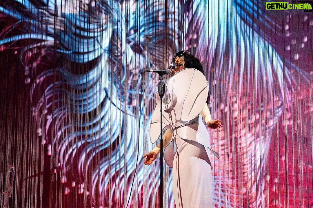 Björk Instagram - thanks for tonight nantes! musicians : @viibraflutes @bergurth @manudelagomusic @katiebuckleyharpist bjork dress @delcoreofficial @danieldelcore latex bodysuit @xvenusprototypex shoes @maisonmargiela floral dress @marni headpieces @james.t.merry musicians outfits @balmain hair @johnvialhair musicians hair @tomikono_wig makeup @isshehungry styling @eddagud photos @santiagraphy Nantes, France