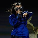 Björk Instagram – @coachella thank you for a magical evening !! 

conductor @bjarnifrimann 
orchestra : hollywood string ensemble 
björk dress @noirkeininomiya 
headpiece @james.t.merry 
bodysuit @solangel 
led sound reacting dress @claradaguin 
silver skirt @weishengparis
makeup @isshehungry 
bjarni frímann top @maisonvalentino 
skirt @weishengparis 
styling @eddagud 
photos @santiagraphy 
drone photos @charles.reagan 
mask design & 3D sculpt @james.t.merry 
mask production @secca_kanazawa 
3D printing support by DMM.make
mask technical direction @suganokaoru 
producer : reiko kunieda 

drone light performance by 
@studio.drift 
@dronestories.show 
@twofiftyk 
@novaskystories 
björk creative direction :
björk , @james.t.merry Coachella