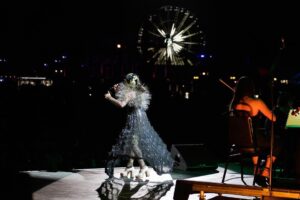 Björk Instagram - thank you @coachella for a wonderful evening !! 
 
conductor @bjarnifrimann 
orchestra : hollywood string ensemble 
björk dresses @noirkeininomiya
headpiece @james.t.merry
latex slip dresses @xvenusprototypex
bodysuit @solangel 
hairpiece @tomikono_wig
makeup @isshehungry
bjarni frimann wearing @jonnycotastudio
styling @eddagud
mask design & 3D sculpt @james.t.merry
mask production @secca_kanazawa
3D printing support by DMM.make
mask technical direction @suganokaoru
producer : reiko kunieda
photos @santiagraphy