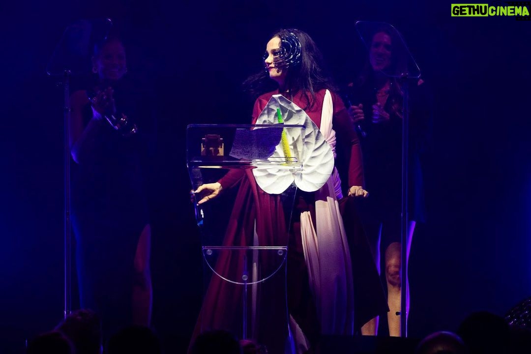 Björk Instagram - so proud to receive this award !! i would like to thank OLI ( one little independent ) who have taken care of me since i was a teenager. so touched to be amongst them UK indies ....... i would like to thank my cornucopia production live crew once again : derek birkett , peter van der velde , bergur þórisson , david levy , john gale , bruno poet , tobias gremmler , lucrecia martel , chiara stephensson , richard white , james merry , edda guðmundsdóttir , rosamari llagostera , heimir sverrison , margrét bjarnadóttir , isshehungry , andrew gallimore , steve jones , santiago felipe thank you @onelittleindierecords @aim_uk bjork dress @richardmalone anthurium flower @loewe mask @james.t.merry makeup @andrewgallimakeup hair @danieldyer72 manicure @suki_nailz styling @eddagud photos @santiagraphy Roundhouse