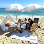 Heather Rae El Moussa Instagram - If only you knew what we went through for this photo! 🩵🌊☀️🍼 Thank you @tableandeve for providing the cutest set up! Sorry the waves had other plans! 😂 Newport Beach, California