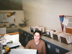 Jenna Fischer Instagram - #OneDayMay Today’s Prompt…Throwback version of me…
 
Here I am working one of my many admin jobs in my years before landing on The Office. Please admire the elaborate filing system behind me. I was very proud of that. I liked this job. I worked as an assistant to a media buyer. It was mostly data entry (and filing). The Dodgers pennant belonged to the assistant before me. The daisies are mine!