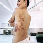 Nathalia Arcuri Instagram - Meu corpo, minha história, minhas flores. E como levou tempo pra eu criar coragem. Doeu, mas não mais do que a jornada. Ficou linda, mas não mais do que a vida que me trouxe até aqui. Tatoo obra de arte por @chiquinhogtattoo Bastidor: Estava eu ensaiando essa tatuagem (repare que tem um coração entrelaçado nas flores) há pelo menos 8 meses, quando no evento de finanças climáticas do G20, no meio de um painel sobre financiamento para a transição justa para energia limpa, vejo as costas pintadas de uma moça… Knoc Knoc (eu nas costas dela) “Nada a ver com o tema, mas quem fez essa tatuagem?” Ela me indicou o artista em questão, @chiquinhogtattoo que conseguiu traduzir em desenho o que se passava dentro do meu coração.