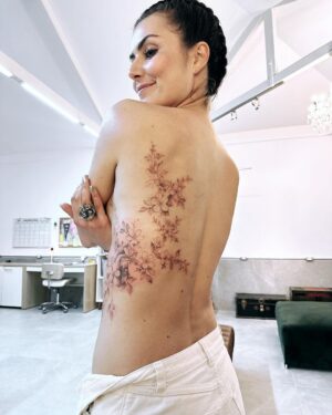 Nathalia Arcuri Instagram - Meu corpo, minha história, minhas flores. 
E como levou tempo pra eu criar coragem. 
Doeu, mas não mais do que a jornada. 
Ficou linda, mas não mais do que a vida que me trouxe até aqui. 

Tatoo obra de arte por @chiquinhogtattoo 

Bastidor: 
Estava eu ensaiando essa tatuagem (repare que tem um coração entrelaçado nas flores) há pelo menos 8 meses, quando no evento de finanças climáticas do G20, no meio de um painel sobre financiamento para a transição justa para energia limpa, vejo as costas pintadas de uma moça… 
Knoc Knoc (eu nas costas dela) 
“Nada a ver com o tema, mas quem fez essa tatuagem?” 
Ela me indicou o artista em questão, @chiquinhogtattoo que conseguiu traduzir em desenho o que se passava dentro do meu coração.