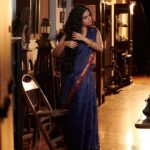 Nikhila Vimal Instagram - Brocade of Mau (historically can have visual similarities with cotton Paithan and venkatgiri cottons too) A revival Mau cotton range of saris with the quintessential 3 cm’s old school ‘chataai’ border consists of uninterrupted gold pattern of diamonds placed in the margins with rows of gold triangles and fine parallel cotton stripes along the edges. The cross border frames a Pallav with two Star Konias. The field of the sari has checks in gold zari over an old indigo ground Muse @nikhilavimalofficial seen draping a Mau cotton revival sari. Featuring- @nikhilavimalofficial Photography - @shafishakkeer HMUA - @rizwan_themakeupboy Styling - @arjun_vasudevs Jewellery - @tanishqjewellery Matancherry