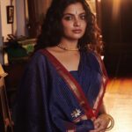 Nikhila Vimal Instagram - Brocade of Mau (historically can have visual similarities with cotton Paithan and venkatgiri cottons too) A revival Mau cotton range of saris with the quintessential 3 cm’s old school ‘chataai’ border consists of uninterrupted gold pattern of diamonds placed in the margins with rows of gold triangles and fine parallel cotton stripes along the edges. The cross border frames a Pallav with two Star Konias. The field of the sari has checks in gold zari over an old indigo ground Muse @nikhilavimalofficial seen draping a Mau cotton revival sari. Featuring- @nikhilavimalofficial Photography - @shafishakkeer HMUA - @rizwan_themakeupboy Styling - @arjun_vasudevs Jewellery - @tanishqjewellery Matancherry