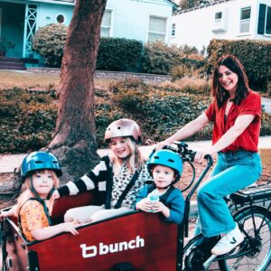 Caterina Scorsone Instagram - Have you been to Holland? One of the rad things about Holland is watching everyone whip around on bikes along the canals. The parents have bicycles with cargo cabs for the kids. Everybody gets to ride. 
October is here, which means it is Down Syndrome Awareness month! Last month @bunchbikes launched the Family Superhero program in an effort to make their awesome bikes more accessible, physically and financially, to more people. 
This bike is roomy, safe, and easy to ride. (And it doesn’t hurt to get a little electric boost when transporting a band of tiny humans around.) My littles and I love our Bunch Bike and we hope you will too! 

Beware! Do not let your toddler bring a random garden gnome with them on the ride. They WILL throw it over the side and the gnome will meet a gruesome demise. RIP Gnome. (It should also be noted that i ALWAYS wear a helmet…except when taking a photograph for an Instagram post.;)

Link in bio for more info about the Bunch Bike Family Superhero Program 🚲 📸 @msage.jpg