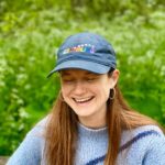 Bonnie Wright Instagram - Say hello to Go Gently’s pride EARTHLING organic cotton baseball cap 🌈🧢 We made this special cap for our documentary TV show hosted by @thisisbwright and @pattiegonia The show is all about celebrating the beautiful spectrum of identities of the folks working to address the climate crisis. The caps are now available for everyone to enjoy as they celebrate love and equality this summer!
$5 from each hat sold will be donated to @bravetrails, a non-profit organization with the mission of connecting LGBTQ  youth to their people, place, and passion. They offer leadership summer camps in California & Maryland, family camps, backpacking, mental health services, and year-round leadership programming. You can learn more about Brave Trails at www.bravetrails.org or by following them @bravetrails
🧢The base colour is navy blue and is made from organic cotton with an adjustable strap for size. Each letter and star represent the colors of the current pride flag. Happy Pride Earthlings 🌈