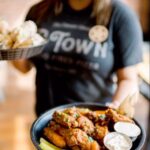 Ree Drummond Instagram - P-Town!! I talk about The Merc most of the time, but our little pizza joint in town is such a delicious gem. Luscious wings, pizza, garlic knots, LASAGNA (new!), and off-the-menu cinnamon knots you’ll see at the end of this video. 🤫 Best team, too!! ❤️ Come sit on the patio and sip a grown-up cherry limeade. 🍒