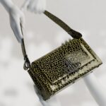 Vivienne Westwood Instagram – Introducing our medium Hazel bag, featuring this season’s ‘Sticky Croc’ design, complete with an imaginary prehistoric reptile motif. The piece is finished with patent embossing, as a playful ode to 80’s style.⁠
⁠
Coming soon.⁠
⁠
⁠
#VWSS24