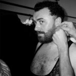 Vivienne Westwood Instagram – BEHIND THE SCENES: Echoing the ‘Blackout’ theme, @samsmith ‘s bespoke Vivienne Westwood show looks are presented in shades and textures of black.⁠
⁠
For the opening look, Sam appears in a double-breasted cropped jacket with braided epaulettes and aiguillettes worn with sailor trousers.⁠
⁠
Later in the show Sam reveals a corseted bodice paired with our iconic SEX choker and spiral lace gloves with claws.