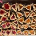 Mayim Bialik Instagram – Hamantaschen stats from yesterday’s baking Live:

Regular —
Chocolate : 25 closed, 0 open – 100% success 
Apricot : 13 closed , 7 open – 65% success 
Strawberry: 5 closed , 13 open – % 28% success 

Gluten Free —
Chocolate : 7 closed , 0 open – 100% success 
Apricot : 10 closed , 2 open – 99 % success 
Strawberry: 9 closed , 3 open , 1 fell on the floor and was this excluded from the tabulation – 75 % success 

First photo – GF
Second photo – Regular 
Third photo – Fred is pointing to the open one he will eat first lol