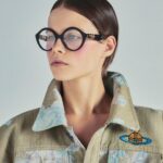 Vivienne Westwood Instagram – Our oversized Cropped Denim Boxer jacket features this season’s floral jacquard, inspired by an archival corset from our Spring-Summer 1998 ‘Tied To The Mast’ collection. ⁠
⁠
Style the piece with our Tyra Toy Box bag, featuring a bone motif that links together with rivets, forming the words ‘Puppy Love’. The style is reminiscent of our Rock chicken bone T-shirt, from the archive ‘Let It Rock’ collection of 1971.⁠
⁠
Now available online and across our boutiques.⁠
⁠
#VWSS24