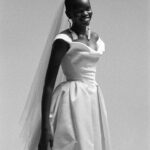 Vivienne Westwood Instagram - Our Nova Bagatelle gown features a design that echoes the iconic blindfolded bride from the Spring-Summer 1997 show, for the 'Vive La Bagatelle' collection. The gown creates a regal silhouette with a cinched waist and a romantic, off-the-shoulder draped neckline. The full skirt features deep pleats and a long almond shaped train. ⁠
⁠
This season the Nova Bagatelle is offered in a double duchesse fabric, styled here with the Ballerina length tulle veil. ⁠
⁠
Photography by @kingsley_ifill⁠
Styling by @florahuddart⁠
⁠
#VWBridal #WestwoodBridal