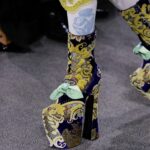 Vivienne Westwood Instagram – ‘She had a very special relationship to time, she truly travelled in her mind’ – Andreas on Vivienne.⁠
⁠
Look #18 from the Andreas Kronthaler for Vivienne Westwood Spring-Summer 2024 collection, featuring elevated platforms, styled alongside a small show tote bag, and the Calypso Dress in sequin cotton lace.⁠
⁠
#AKVWSS24