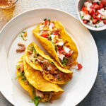 Martha Stewart Instagram – For an a-maize-ing upgrade, this easy dinner recipe has you quickly fry soft corn tortillas in hot oil just until their edges are crisp. This turns them into a crispy handheld treat filled with a hearty mix of shredded chicken thighs and a quick homemade tomato salsa. Get the recipe at the link in our bio. 📷: @paolaandmurray recipe: @lucullanfoods food styling: @brooklyncooks prop styling: @suzie_myers