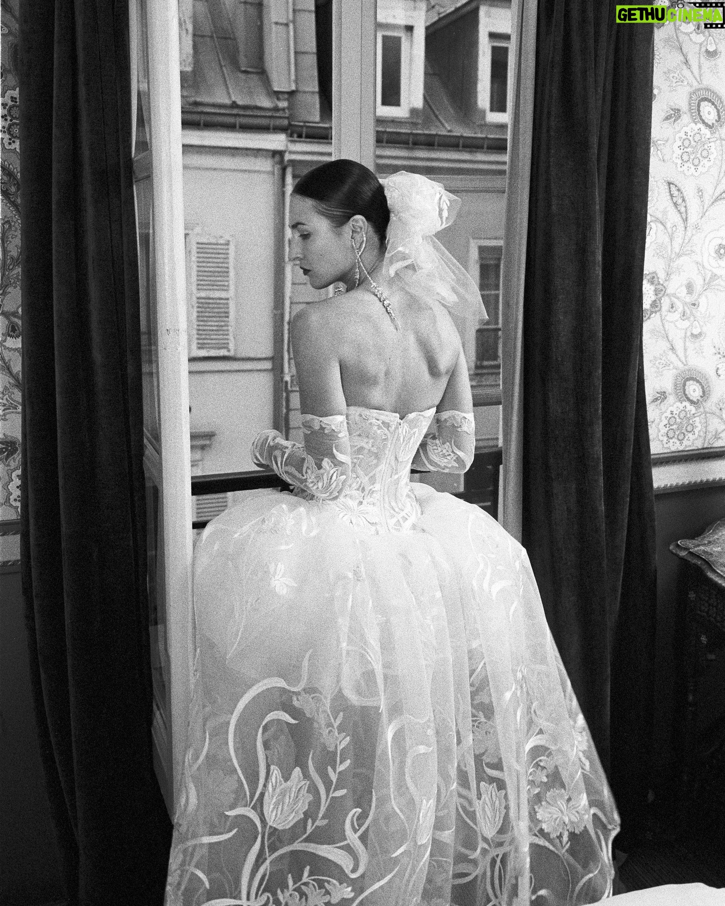 Vivienne Westwood Instagram - The Eline gown offers an unwavering sense of romanticism, embroidered with a Flora motif, taken from an archival couture lace.
The dress features a voluminous skirt with panniers, along with a straight neckline and transparent boned low hip corset bodice, accentuating the waistline.
The look is styled with fingerless gloves, echoing the decorative detail of the dress.
Photography by @kingsley_ifill
Styling by @florahuddart
Talent: @elinehoyois
#VWBridal #WestwoodBridal