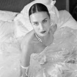Vivienne Westwood Instagram – The Eline gown offers an unwavering sense of romanticism, embroidered with a Flora motif, taken from an archival couture lace. ⁠
⁠
The dress features a voluminous skirt with panniers, along with a straight neckline and transparent boned low hip corset bodice, accentuating the waistline. ⁠
⁠
The look is styled with fingerless gloves, echoing the decorative  detail of the dress. ⁠
⁠
Photography by @kingsley_ifill⁠
Styling by @florahuddart⁠
Talent: @elinehoyois⁠
⁠
#VWBridal #WestwoodBridal